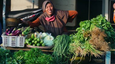 Bantul pazarında satıcı tezgahında çeşitli sebzeler. Odaklanma seçildi. Bulanık tüccar yüzü arka planı