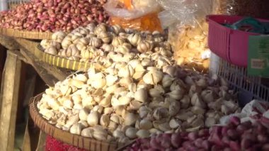 Geleneksel bir pazarda sabah güneşine maruz kalmış bir sepetin üzerinde sarımsak.