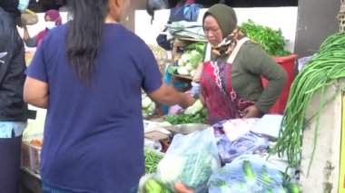Sabahları geleneksel pazardan sebze alıp satmak.