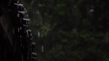 Çatı kiremitlerinden damlayan yağmur suyu. Seçili koyu bulanık arkaplana odaklan