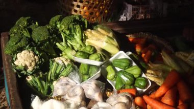 Geleneksel bir pazarda sabah güneşine maruz kalan çeşitli sebzeler. Brokoli, havuç, chayote, domates. Seçilene odaklan