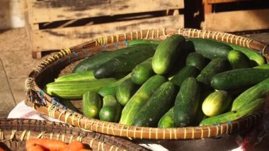 Salatalıklar, havuçlar ve domatesler bambu sepetlerinde geleneksel bir pazarda güneş ışığına maruz kaldı. Seçilene odaklan