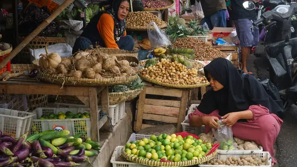 Yogyakarta, Endonezya. 3 Mayıs 2024. Geleneksel Bantul pazarında sabah atmosferi. Alıcılar limon seçiyor. Seçilene odaklan