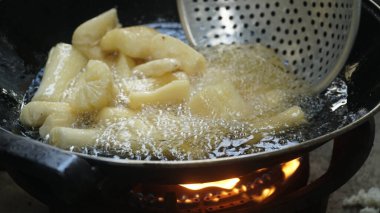 Cassava kızartma tavasında kızartılıyor. Kızarmış Cassava geleneksel Endonezya yemeğidir. Seçilene odaklan