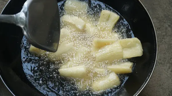 Cassava kızartma tavasında kızartılıyor. Kızarmış Cassava geleneksel Endonezya yemeğidir. Seçilene odaklan