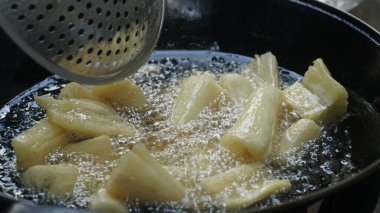 Cassava kızartma tavasında kızartılıyor. Kızarmış Cassava geleneksel Endonezya yemeğidir. Seçilene odaklan