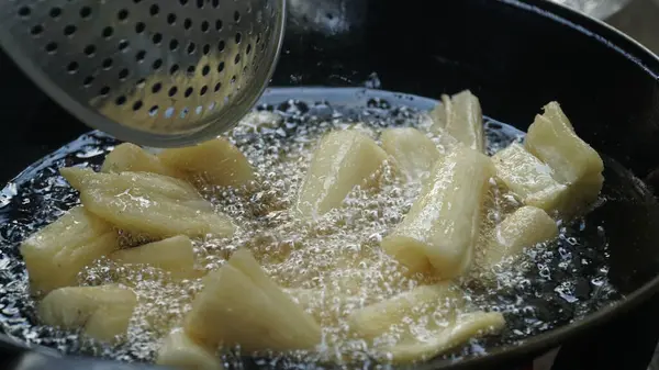 Cassava kızartma tavasında kızartılıyor. Kızarmış Cassava geleneksel Endonezya yemeğidir. Seçilene odaklan