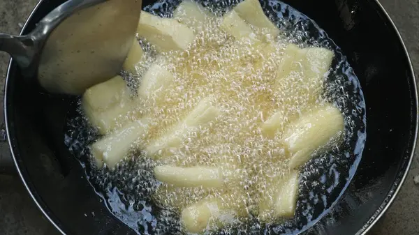 Cassava kızartma tavasında kızartılıyor. Kızarmış Cassava geleneksel Endonezya yemeğidir. Seçilene odaklan