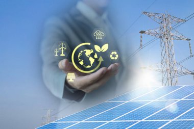 İş adamının elinde fotovoltaik sistemdeki güneş panelleri, temiz enerji, yüksek voltaj kulesi üzerindeki yeşil bitki simgesi var. temiz enerji kavramı