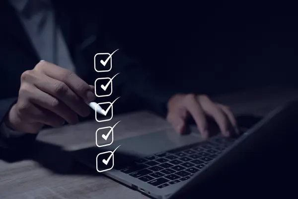 Dijital form kontrol listesini tamamla İş adamı sanal ekran anketini tamamlamak için dizüstü bilgisayar kullanır