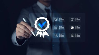 ISO Sertifikalama ve Kalite Güvencesi İşadamı bilgisayar ve tabletle çalışarak standartlara uyduğunu gösteriyor