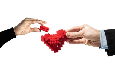 İki kişi bir çocuk inşaatından bir kalp yapıyor..