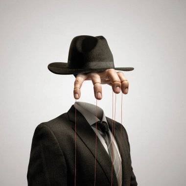 Parmaklarına ip bağlanmış bir el keçeli bir şapkadan sarkıyor. Sanat kolajı.