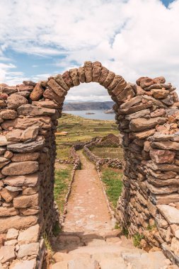 Puno Peru 'da, Titicaca Gölü' ndeki Amantani adasındaki bir dağın tepesindeki taş kemer.