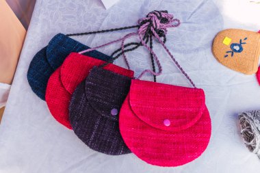 El yapımı, alpaka lifiyle örülmüş çok renkli başlık. Atalarından kalma tasarımlar ve çarpıcı renklerin geometrik figürleri. Masaya yerleştirilmiş beyaz masa örtüsü, doğal ışıkla aydınlatılmış.