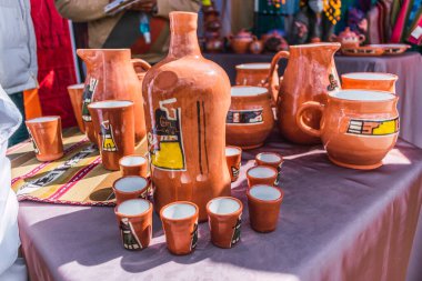 El yapımı, alpaka lifiyle örülmüş çok renkli başlık. Atalarından kalma tasarımlar ve çarpıcı renklerin geometrik figürleri. Masaya yerleştirilmiş beyaz masa örtüsü, doğal ışıkla aydınlatılmış.