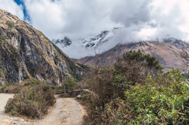 Peru cusco 'nun And Dağları' ndaki Humantay gölünde karla kaplı bulutlarla çevrili dağlar.