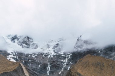 Peru cusco 'nun And Dağları' ndaki Humantay gölünde karla kaplı bulutlarla çevrili dağlar.
