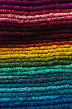 El yapımı, alpaka lifiyle örülmüş çok renkli başlık. Atalarından kalma tasarımlar ve çarpıcı renklerin geometrik figürleri. Masaya yerleştirilmiş beyaz masa örtüsü, doğal ışıkla aydınlatılmış.