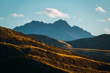Gün batımında kar dağı, And Dağları 'nda bulutlar ve mavi gökyüzü.