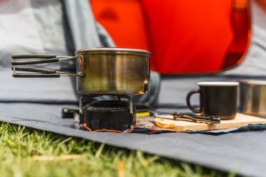 Turuncu çadır arka planda kamp malzemesi. And Dağları 'nın doğal ışıklarıyla aydınlatılmış yeşil çimenler.