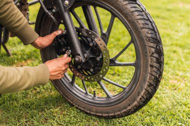Güneşli bir günde bulutlu bir havada siyah motosiklet ön diski fren yaptı.