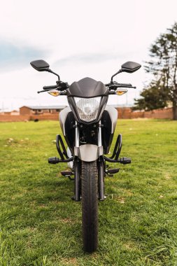 Güneşli bir günde bulutlu bir havada duran siyah motosiklet.