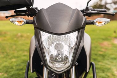 Güneşli bir günde bulutlu bir havada duran siyah motosiklet.