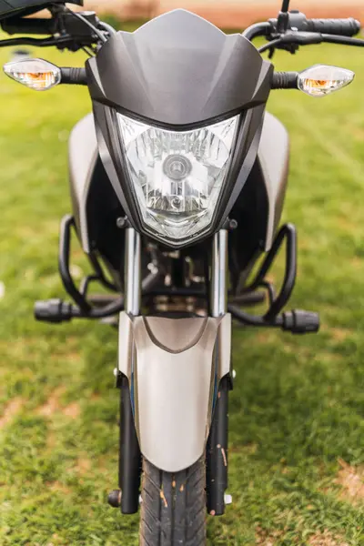 Güneşli bir günde bulutlu bir havada duran siyah motosiklet.