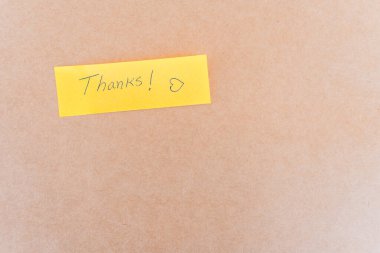 Teşekkürler yazan bir not: Sağlam bir arkaplanda mavi kalemle yazılmış bir teşekkür notu.