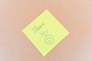 Teşekkürler yazan bir not: Sağlam bir arkaplanda mavi kalemle yazılmış bir teşekkür notu.