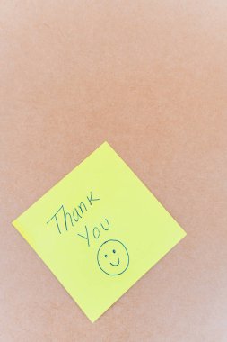 Teşekkürler yazan bir not: Sağlam bir arkaplanda mavi kalemle yazılmış bir teşekkür notu.