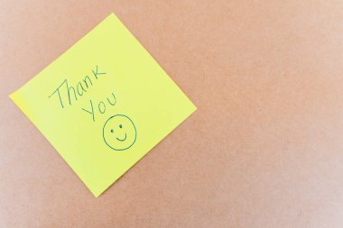 Teşekkürler yazan bir not: Sağlam bir arkaplanda mavi kalemle yazılmış bir teşekkür notu.