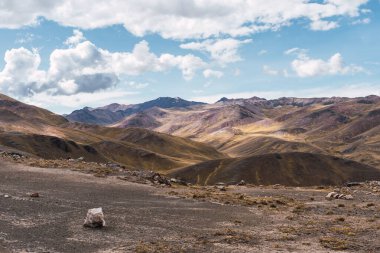 And Platosu 'nun manzarası, dağ sırası ve pek çok fırtına bulutu ve mavi gökyüzü olan seyrek bitki örtüsü.
