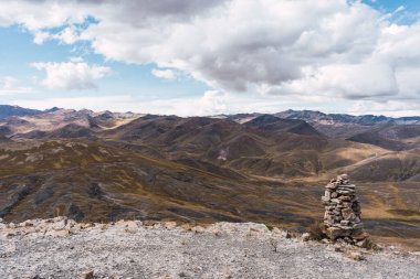 And Platosu 'nun manzarası, dağ sırası ve pek çok fırtına bulutu ve mavi gökyüzü olan seyrek bitki örtüsü.
