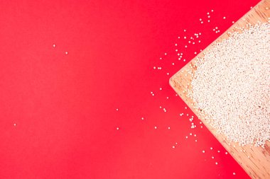 Eski bir seramik kasede renkli bir kumaşın üzerinde siyah bir kaşık olan kinoa.