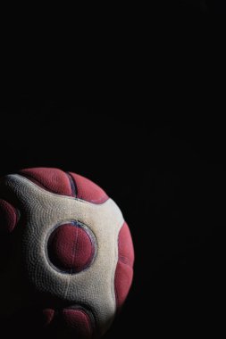 Siyah arka planda beyaz çizgileri olan kırmızı bir topa yakın plan.