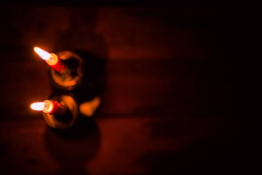 Bir şamdanda yanan ve yanmayan mumlar karanlık bir arka plana karşı, sıcaklık ve hatırayı çağrıştırıyor..