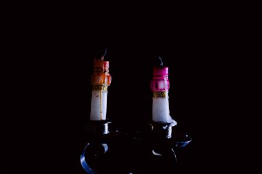 Bir şamdanda yanan ve yanmayan mumlar karanlık bir arka plana karşı, sıcaklık ve hatırayı çağrıştırıyor..