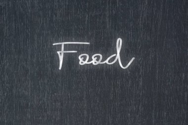 A blackboard with a handwritten chalk message that says food, a powerful symbol of business success and motivation in educational and production concepts.