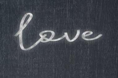Üzerinde el yazısıyla yazılmış aşk yazan bir karatahta, iş dünyasının başarısının ve eğitim ve üretim kavramlarındaki motivasyonun güçlü bir sembolü..