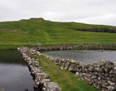 Broch of Culswick. Mainland, Shetland Islands. Culswick Broch is an unexcavated coastal broch in Mainland, in the Shetland Islands. Scotland. The monument comprises a broch of Iron Age date, built probably between 500 BC and AD 200.  clipart