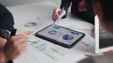 İş arkadaşları ofislerindeki mali verileri ve stratejileri analiz ediyorlar - takım üyeleri olarak finansal stratejileri yorumlamak ve planlamak için birlikte çalışan profesyonel ve işbirlikçi bir atmosfer.