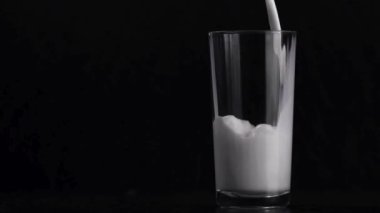 Siyah arkaplana süt dökmek - Sahnenin basitliği ve katıksız kontrastın birleşimi, sütün saflığını ve tazeliğini vurgular, onu görsel olarak büyüleyici ve rahatlatıcı bir an yapar..