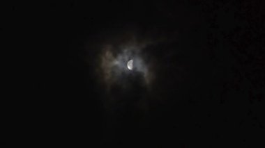 Gece gökyüzünde bulutlarla dolunay. Bu görüntüler, ayın sabit parlaklığını bulutların akışkan hareketiyle harmanlayan, huzurlu ama büyüleyici bir gece görüntüsü sunuyor..
