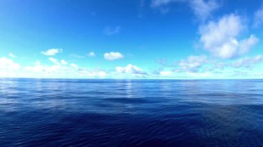Sakin mavi okyanus suyu, sakin bir günde berrak gökyüzünün altında dalgalanır.