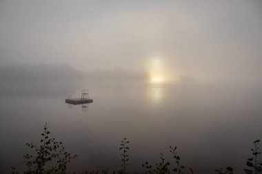 Gün doğumunda göle yansıyan sisli güneş iskele manzarası. Oxlanguage Gölü, Ontario, Kanada