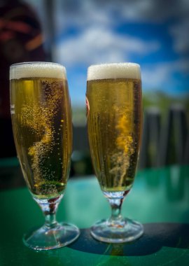 Güneşin altında soğuk biralar eşliğinde. Bulanık arkaplan.