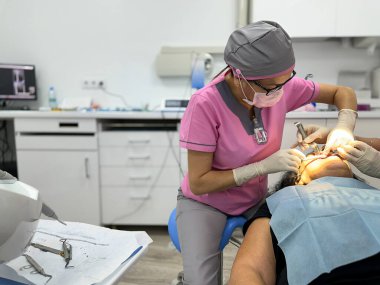 Bir hastaya diş hekimi ameliyatı yapıyor..