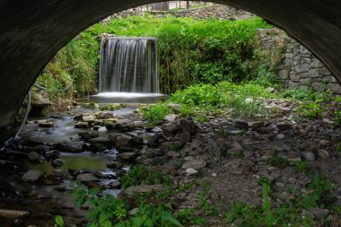 Andorr 'un merkezinde yeşilliklerle çevrili küçük şelale.